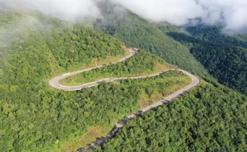 Serra da Rocinha é inaugurada após uma década de obras Vista aérea das curvas sinuosas e pavimentadas da Serra da Rocinha na BR-285, cercada por densa vegetação de Mata Atlântica e nuvens no Extremo Sul Catarinense.