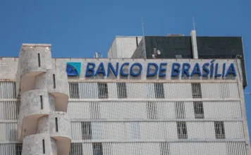 BRB convoca assembleia para aprovar aumento de capital Fachada externa do edifício da sede do Banco de Brasília (BRB) em Brasília, com destaque para o letreiro azul da instituição e arquitetura moderna sob céu limpo. Imagem focada em economia, mercado financeiro e gestão pública do Distrito Federal.