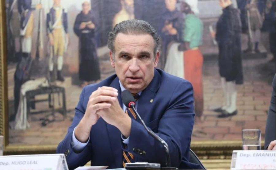 Câmara aprova volta de cidade e estado em placas de veículos Retrato do deputado Hugo Leal discursando em uma audiência da Câmara dos Deputados sobre a aprovação do projeto de lei (PL 3214/23) para placas veiculares.