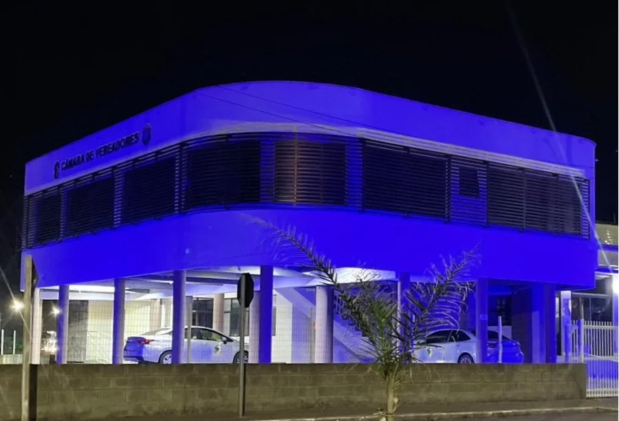 Fachada do prédio da Câmara de Vereadores de Balneário Arroio do Silva iluminada com luzes azuis em alusão ao mês de conscientização sobre o autismo (TEA).