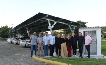 Câmara de Forquilhinha investe em energia solar e economia Autoridades e vereadores de Forquilhinha em frente à nova usina solar modelo carport instalada no estacionamento da Câmara Municipal. A estrutura metálica sustenta painéis solares fotovoltaicos sobre as vagas de veículos para geração de energia limpa e sustentável.