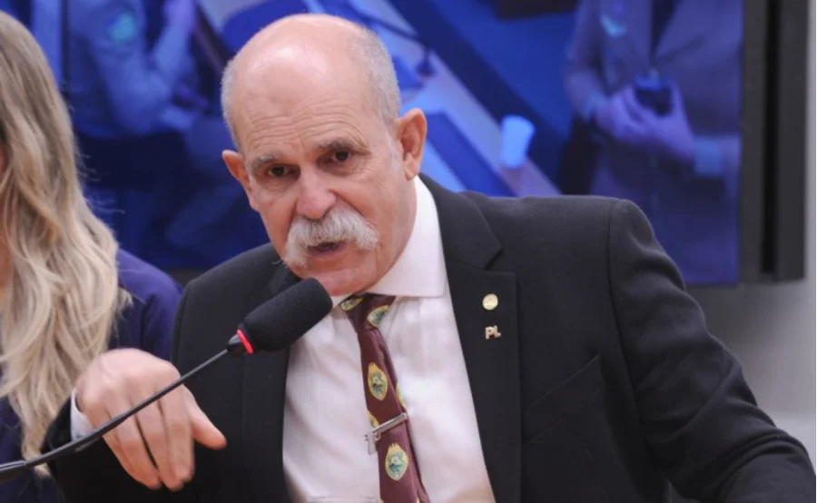 O deputado Sargento Fahur (PL-PR), relator da proposta de alteração do Código Penal Militar, falando em um microfone durante reunião de comissão na Câmara dos Deputados em Brasília sobre a definição de atividade de natureza militar.