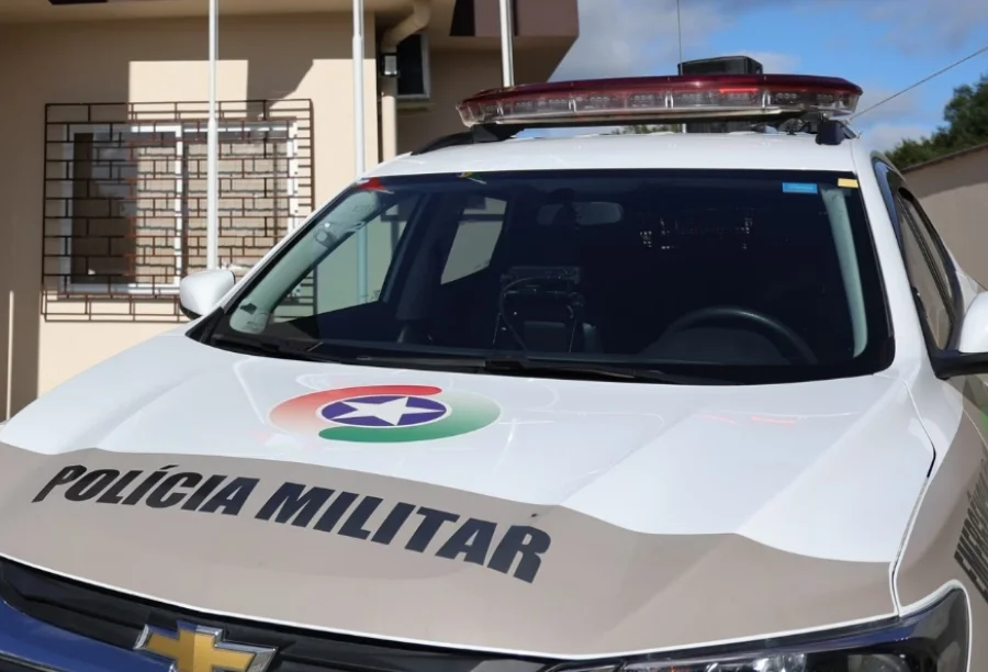 Viatura da Polícia Militar de Santa Catarina (PMSC) estacionada durante atendimento de ocorrência de ameaça e injúria em Turvo. O veículo branco exibe o logotipo oficial da corporação e o giroflex vermelho.