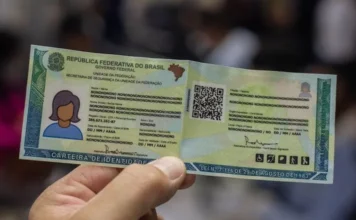 Como solicitar a segunda via da nova identidade online em SC Pessoa segurando a nova Carteira de Identidade Nacional (CIN) em Santa Catarina, destacando o documento unificado que utiliza o CPF como número de identificação.