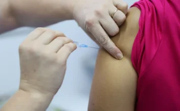 Criciúma aplica 15 mil doses contra a gripe em 10 dias Close-up de profissional de saúde aplicando dose da vacina trivalente contra a gripe (influenza) no braço de uma pessoa durante a campanha de vacinação em Criciúma.