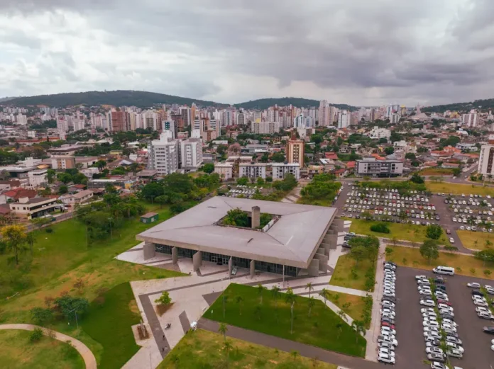 Criciúma convoca aposentados para prova de vida obrigatória Vista aérea do Paço Municipal Marcos Rovaris em Criciúma, destacando a arquitetura do prédio da prefeitura onde ocorre o recadastramento e a prova de vida dos aposentados e pensionistas municipais.
