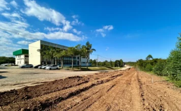 Criciúma lança obra de R$ 6,2 milhões para nova via Vista aérea das obras de terraplanagem da nova via de ligação entre as rodovias Governador Jorge Lacerda e Antônio Just em Criciúma, mostrando o traçado de terra ao lado do Centro Tecnológico Satc sob céu azul.