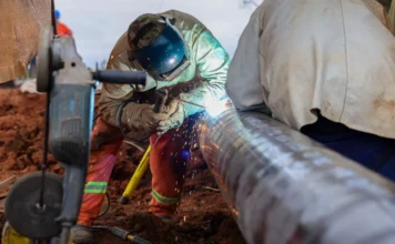 Criciúma lidera consumo de gás natural em Santa Catarina Trabalhador especializado realiza soldagem em tubulação de aço da rede de gás natural da SCGÁS em Santa Catarina. A imagem destaca a expansão da infraestrutura de distribuição de energia para atender polos industriais catarinenses.