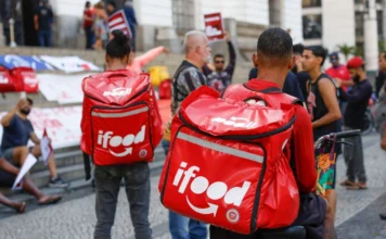 Decisão unânime isenta iFood de pagar dívida a entregador Entregadores do iFood com mochilas térmicas vermelhas em destaque, representando a categoria de trabalhadores de aplicativos em meio a discussões sobre vínculo empregatício e decisões do TST.