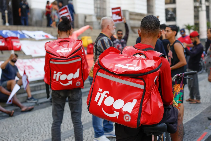 Decisão unânime isenta iFood de pagar dívida a entregador Entregadores do iFood com mochilas térmicas vermelhas em destaque, representando a categoria de trabalhadores de aplicativos em meio a discussões sobre vínculo empregatício e decisões do TST.