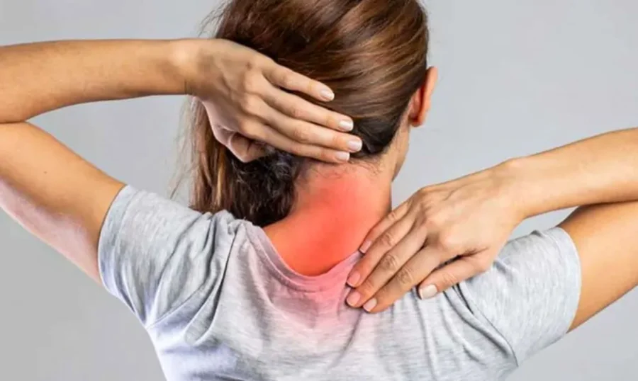 Mulher de costas com as mãos na nuca e área da coluna cervical realçada em vermelho, ilustrando sintomas de dor e localização de neoplasia cervical e câncer de cabeça e pescoço.