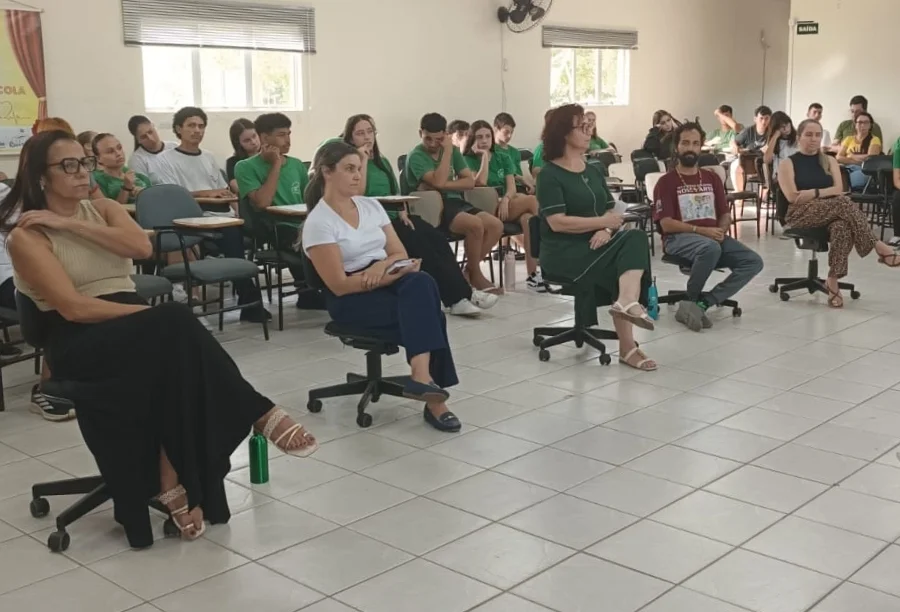 Reunião sobre inclusão escolar na EEB João dos Santos Areão em Santa Rosa do Sul, mostrando alunos e profissionais sentados em auditório durante palestra sobre educação especial.
