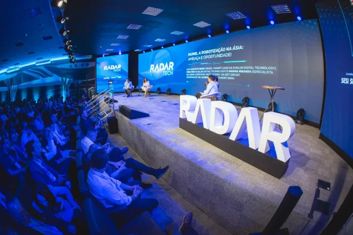 FIESC Tecnologia é vital para a indústria catarinense Público assiste ao painel sobre robotização na Ásia durante o evento Radar Tech da FIESC em Florianópolis, destacando a modernização da indústria catarinense e o debate sobre tecnologias emergentes.