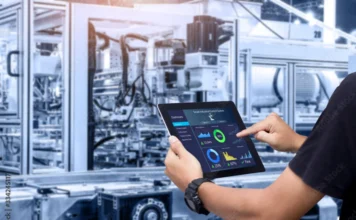 FIESC debate expansão da robótica industrial no Radar Tech Técnico operando um tablet com painel de controle digital em uma fábrica de robótica industrial automatizada. A imagem ilustra o controle e monitoramento para ganho de produtividade e redução de custos, temas centrais do Radar Tech da FIESC.