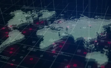 FIESC debate o novo tabuleiro global bélico Mapa múndi digital estilizado com pontos de dados brilhantes e grade tecnológica, simbolizando a ciberdefesa e a integração de dados na nova geopolítica global discutida pela FIESC.