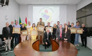 Forquilhinha celebra 37 anos com entrega de honrarias Homenageados e autoridades locais seguram certificados durante sessão solene na Câmara de Vereadores em celebração aos 37 anos de emancipação de Forquilhinha, Santa Catarina.