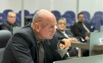 Ghiraldo alerta para alta de feminicídios no Sul do estado Vereador Jorge Ghiraldo, com tatuagens faciais visíveis, falando em um microfone durante uma sessão na Câmara de Vereadores sobre o aumento da violência contra a mulher. Ele veste um terno e gesticula.