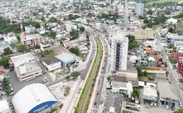 Governo lança maior pacote de obras de Morro da Fumaça Vista aérea do centro urbano de Morro da Fumaça, em Santa Catarina, destacando o Ginásio de Esportes Jorge Silva e as avenidas centrais que integram o plano de investimentos e desenvolvimento municipal.
