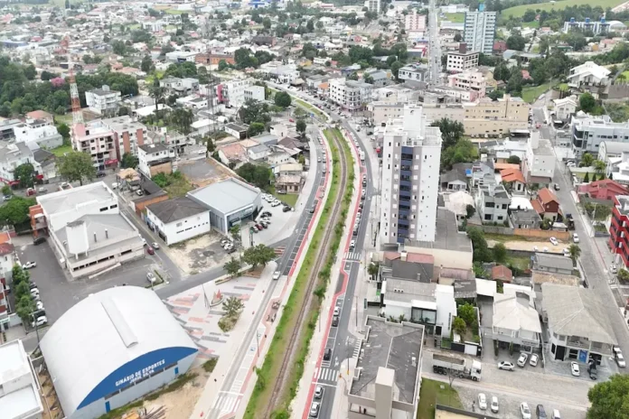 Governo lança maior pacote de obras de Morro da Fumaça Vista aérea do centro urbano de Morro da Fumaça, em Santa Catarina, destacando o Ginásio de Esportes Jorge Silva e as avenidas centrais que integram o plano de investimentos e desenvolvimento municipal.