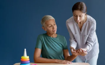 Home care contrata terapeutas ocupacionais no Sul de SC Imagem ilustrativa de uma terapeuta ocupacional realiza sessão de reabilitação motora e cognitiva com paciente idosa em atendimento domiciliar na região de Criciúma.