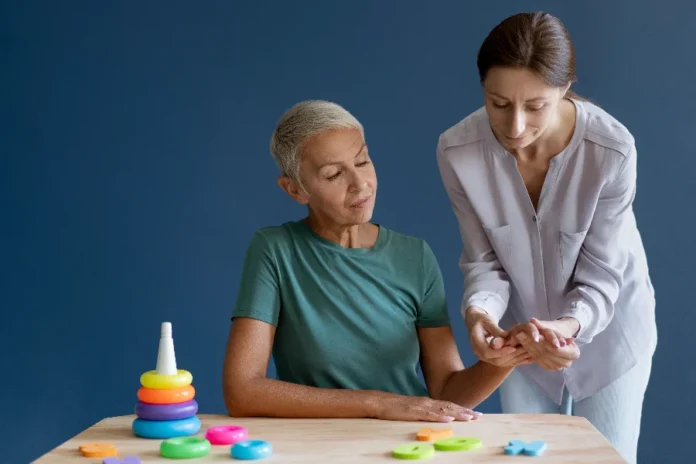 Home care contrata terapeutas ocupacionais no Sul de SC Imagem ilustrativa de uma terapeuta ocupacional realiza sessão de reabilitação motora e cognitiva com paciente idosa em atendimento domiciliar na região de Criciúma.