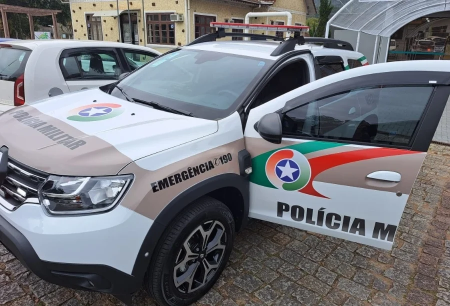 Viatura da Polícia Militar de Santa Catarina (PMSC) estacionada em via pública durante atendimento de ocorrência policial em Criciúma. O veículo, um modelo Renault Duster, exibe a padronização oficial da corporação.