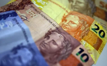 IR 2026: saiba como escolher o melhor modelo de declaração Cédulas de Real brasileiras em destaque, com notas de 10, 20 e 50 reais sobrepostas, representando o planejamento financeiro e a restituição do Imposto de Renda 2026 da Receita Federal.