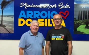 Jairo de Matos assume Secretaria no Arroio do Silva O prefeito Jorge Luiz Freitas e o novo secretário de Administração e Finanças, Amarante Jairo de Matos, posam juntos em frente ao painel institucional da Prefeitura de Balneário Arroio do Silva.