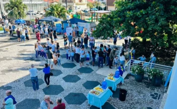 Meleiro promove ação integrada com 172 atendimentos na praça Vista aérea da praça central de Meleiro durante ação integrada da prefeitura, mostrando tendas de atendimento, profissionais de saúde e educação, e grande movimentação de moradores em um dia ensolarado.