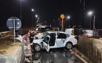 Sobe para dois o número de mortos em acidente na BR-101 Acidente fatal na BR-101 em São João do Sul mostra veículo branco com a frente destruída após colisão frontal contra mureta de concreto em praça de pedágio durante a noite.