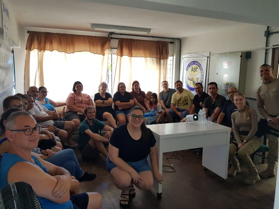 Policiais militares e integrantes da Associação de Surdos de Criciúma (ASC) posam para foto durante palestra sobre o programa de acessibilidade SC em Libras na sede da entidade.