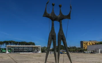 Pensões no STF custam R$ 4,8 milhões por ano aos cofres Escultura Os Candangos em destaque na Praça dos Três Poderes, com o edifício do Supremo Tribunal Federal (STF) ao fundo em Brasília. A imagem ilustra a sede da Corte que despende R$ 4,8 milhões anuais em pensões para dependentes de ex-ministros e servidores.
