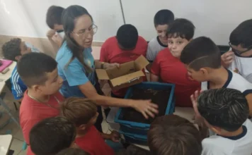 Projeto da Unesc vence edital nacional da SBPC em Araranguá Professora demonstra a atividade de compostagem para alunos em sala de aula da Escola Professor Mota Pires em Araranguá, SC. A atividade integra o projeto de agroecologia da Unesc selecionado pelo edital nacional SBPC vai à Escola. Os estudantes observam a composteira doméstica e o solo orgânico, aprendendo sobre sustentabilidade e educação ambiental do campo.