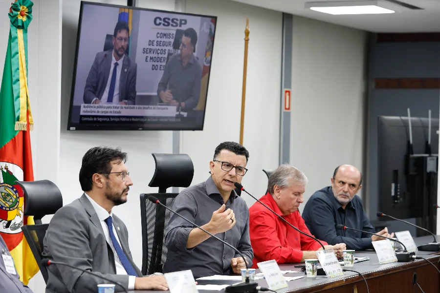 Deputado Jeferson Fernandes discursa durante audiência pública sobre transporte rodoviário de cargas na Assembleia Legislativa do Rio Grande do Sul, com foco nos desafios dos caminhoneiros e infraestrutura das estradas gaúchas.