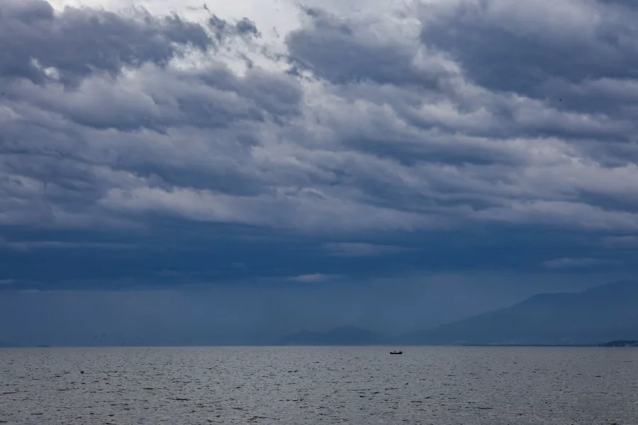 Nuvens densas e carregadas de cor cinza escuro sobre o mar em Santa Catarina, sinalizando a chegada de uma frente fria com risco de temporais e instabilidade no tempo.