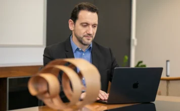 SESI/SC busca modelo de saúde digital na Espanha Daniel Tenconi, superintendente do SESI/SC, sentado à mesa de escritório utilizando um notebook. A imagem ilustra a liderança da entidade na busca por soluções de tecnologia, saúde digital e integração de dados para o setor industrial catarinense.