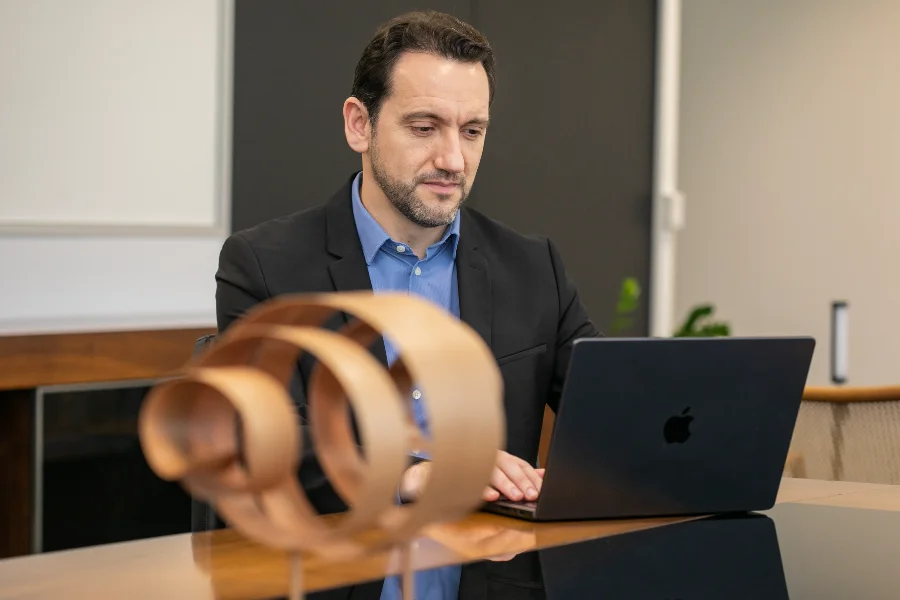 Daniel Tenconi, superintendente do SESI/SC, sentado à mesa de escritório utilizando um notebook. A imagem ilustra a liderança da entidade na busca por soluções de tecnologia, saúde digital e integração de dados para o setor industrial catarinense.