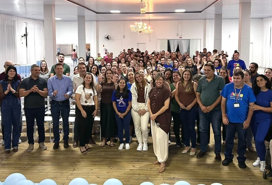 Público e autoridades municipais reunidos no evento Abril Azul em São João do Sul, com a palestrante Bel Ferrari ao centro, em momento de conscientização sobre o autismo e inclusão de mães atípicas.