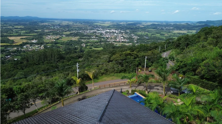 Vista aérea panorâmica da Serra do Faxinal em Praia Grande, Santa Catarina, destacando a rodovia SC-290 e a nova infraestrutura de postes da rede trifásica de energia instalada para atender o setor de turismo.