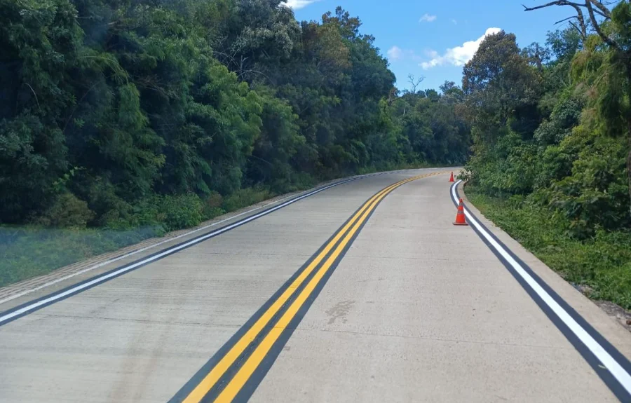 oto do trecho pavimentado em concreto da rodovia SC-290, Serra do Faxinal, com cones de sinalização laranjas no acostamento e mata nativa ao redor.