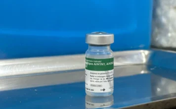 Siderópolis recebe novas doses da vacina contra influenza Frasco de vidro da vacina contra a gripe influenza tipos A/H1N1 e A/H3N2 posicionado sobre uma bandeja de inox em Unidade Básica de Saúde de Siderópolis.