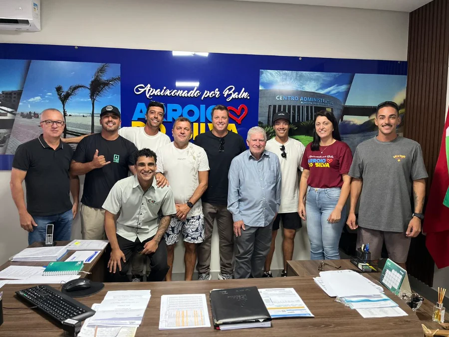 Surf ganha destaque na 33ª Festa do Peixe no Arroio Uma foto oficial de um grupo de 10 pessoas posando no gabinete do prefeito de Balneário Arroio do Silva, em frente a um grande painel azul com o slogan 'Apaixonado por Balneário ARROIO DO SILVA'. O Prefeito Jorge Freitas (homem mais velho de camisa azul clara) está no centro, cercado por integrantes da diretoria da Associação de Surf de Balneário Arroio do Silva (ASBAS), incluindo o vereador Clailton Oliveira (ao seu lado esquerdo), e as secretárias Itaionara Recco e Amarante Jairo de Matos.