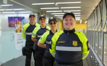 Trânsito de Criciúma adota padrão nacional de uniformes Agentes de trânsito de Criciúma em fila vestindo os novos uniformes nas cores amarelo neon e preto, com detalhes refletivos e o brasão do município para maior segurança viária.