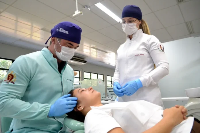 Unesc alerta para danos do bruxismo na rotina atual O cirurgião-dentista e professor Felipe Veronez realiza exame clínico em paciente no Núcleo de Dor Orofacial (Nudof) da Unesc para diagnóstico de bruxismo e tensões musculares. Ao lado, a acadêmica Larissa Amaral acompanha o procedimento em ambiente odontológico.