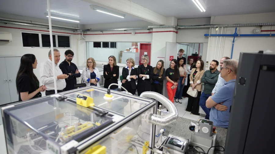 Lideranças da Acic e gestores da Unesc em visita técnica ao laboratório do Iparque, em Criciúma. O grupo observa equipamentos de alta tecnologia e inovação voltados ao desenvolvimento do setor produtivo regional.