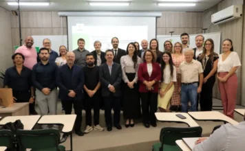 Unesc inicia primeira turma de Doutorado em Direito Grupo de professores e alunos da primeira turma do Doutorado em Direito da Unesc reunidos em sala de aula para a aula magna em Criciúma. Ao fundo, tela de projeção e banners da universidade. Foto com foco na formação jurídica e Direitos Humanos.