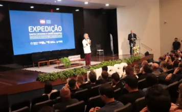 Unesc recebe expedição da União Europeia para inovação Reitora em exercício da Unesc, Gisele Silveira Coelho Lopes, discursa no palco durante a 4ª Expedição Santa Catarina e União Europeia em Criciúma. Ao fundo, tela azul exibe o nome do evento sobre oportunidades de fomento em ciência, tecnologia e inovação para pesquisadores e empreendedores.