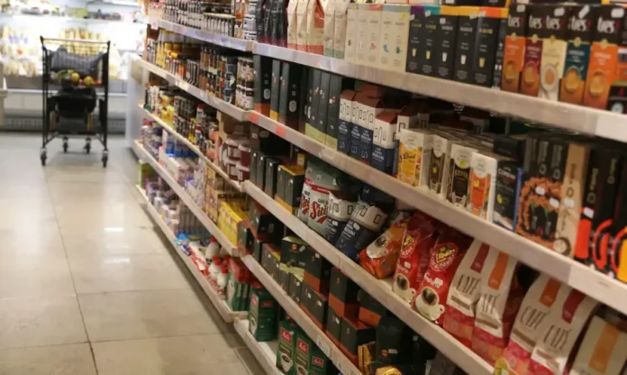 Varejo brasileiro bate recorde histórico em fevereiro Prateleiras de supermercado repletas de produtos alimentícios e bebidas, destacando o setor de hipermercados que impulsionou o recorde de vendas do varejo brasileiro em 2026.