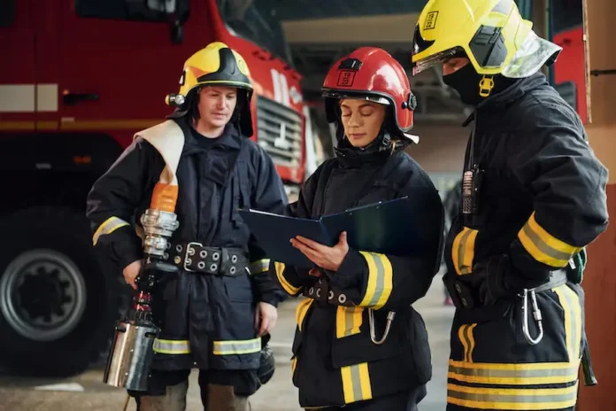 com-bloco-de-notas-grupo-de-bombeiros-em-uniforme-de-protecao-que-esta-na-estacao_146671-53997