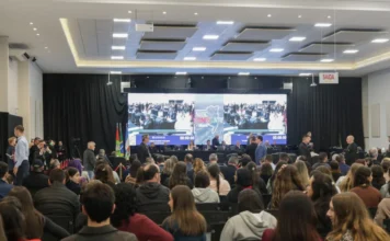 Alesc Itinerante reúne 1,5 mil pessoas em Araranguá Plenário do programa Alesc Itinerante em Araranguá com público assistindo à sessão da Assembleia Legislativa de Santa Catarina no Centro Multiuso Arlete Cristiano Salomé. Ao fundo, grande painel de LED exibe a transmissão do evento e a identidade visual do projeto.